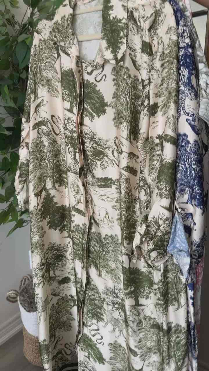Cream garment with a green woodland print, displayed on a hanger.